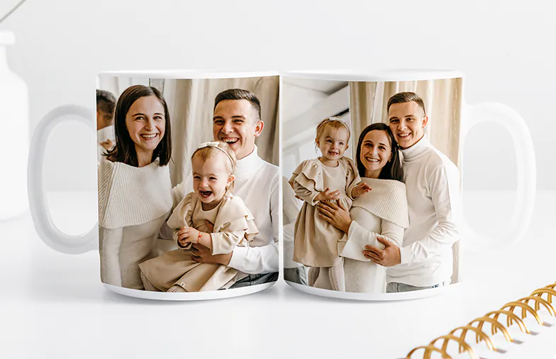["Personalised Photo Mugs by Printerpix", "Mother and baby holding a mug with Printerpix cartoon design and 'Daddy' text", "Personalised photo mug with image of a crawling baby in an animal onesie", "Mother and daughter holding custom-designed photo mugs with family photos", "Kissing couple with personalised mugs with text", "Personalised photo mug with own photo of a dog", "", "", "", "", ""]||||||||||