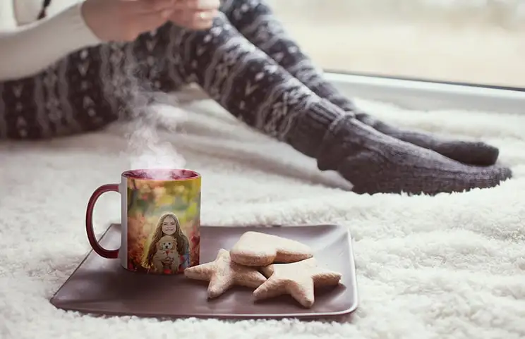 Personalisierte rote Tasse mit Foto eines jungen Mädchens neben Keksen